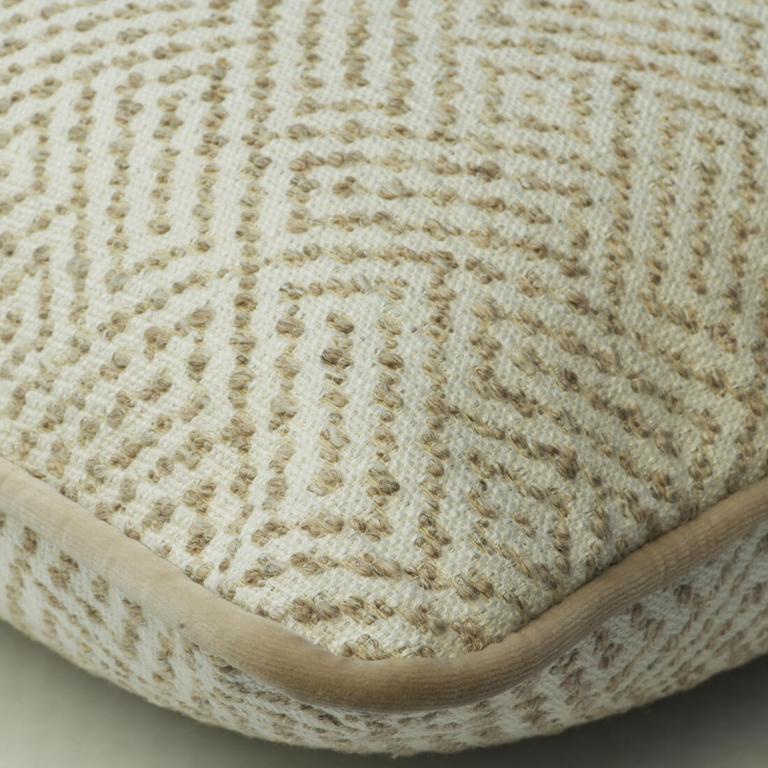 Luxury beige and ivory cushion with a textured geometric diamond weave and soft piped trim.