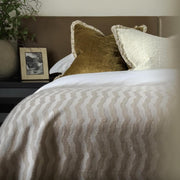 Andrew Martin tan Merino wool throw with geometric pattern and fringe