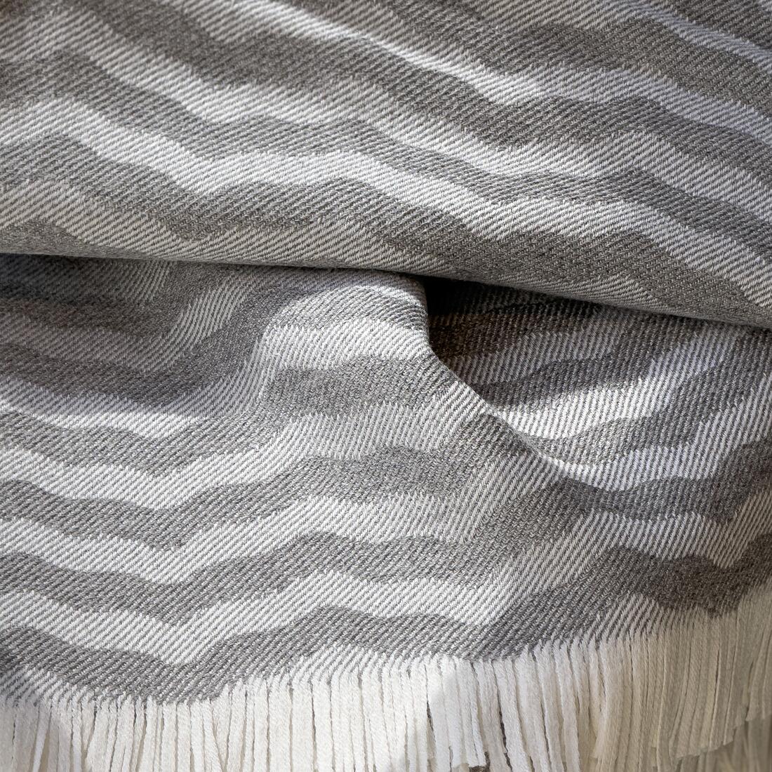 Andrew Martin tan Merino wool throw with geometric pattern and fringe