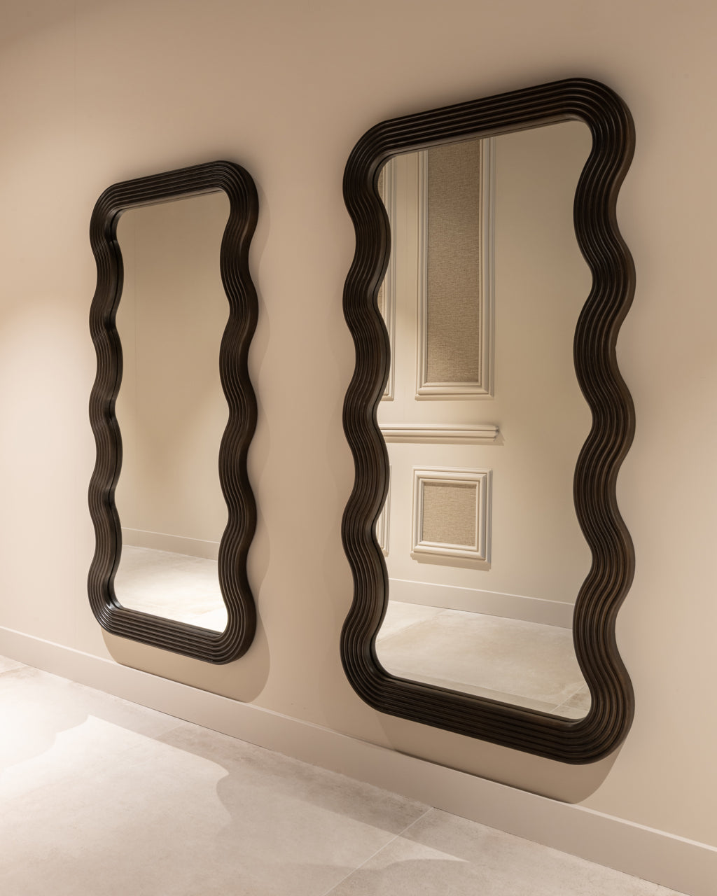 Modern wavy full length mirror with dark wood frame and sculptural curved design