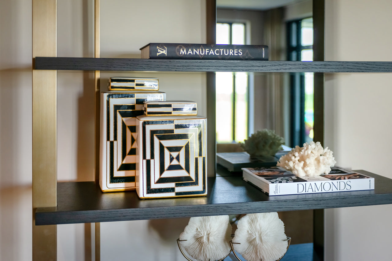 Modern wall shelving unit with mirror back gold frame and dark wood shelves
