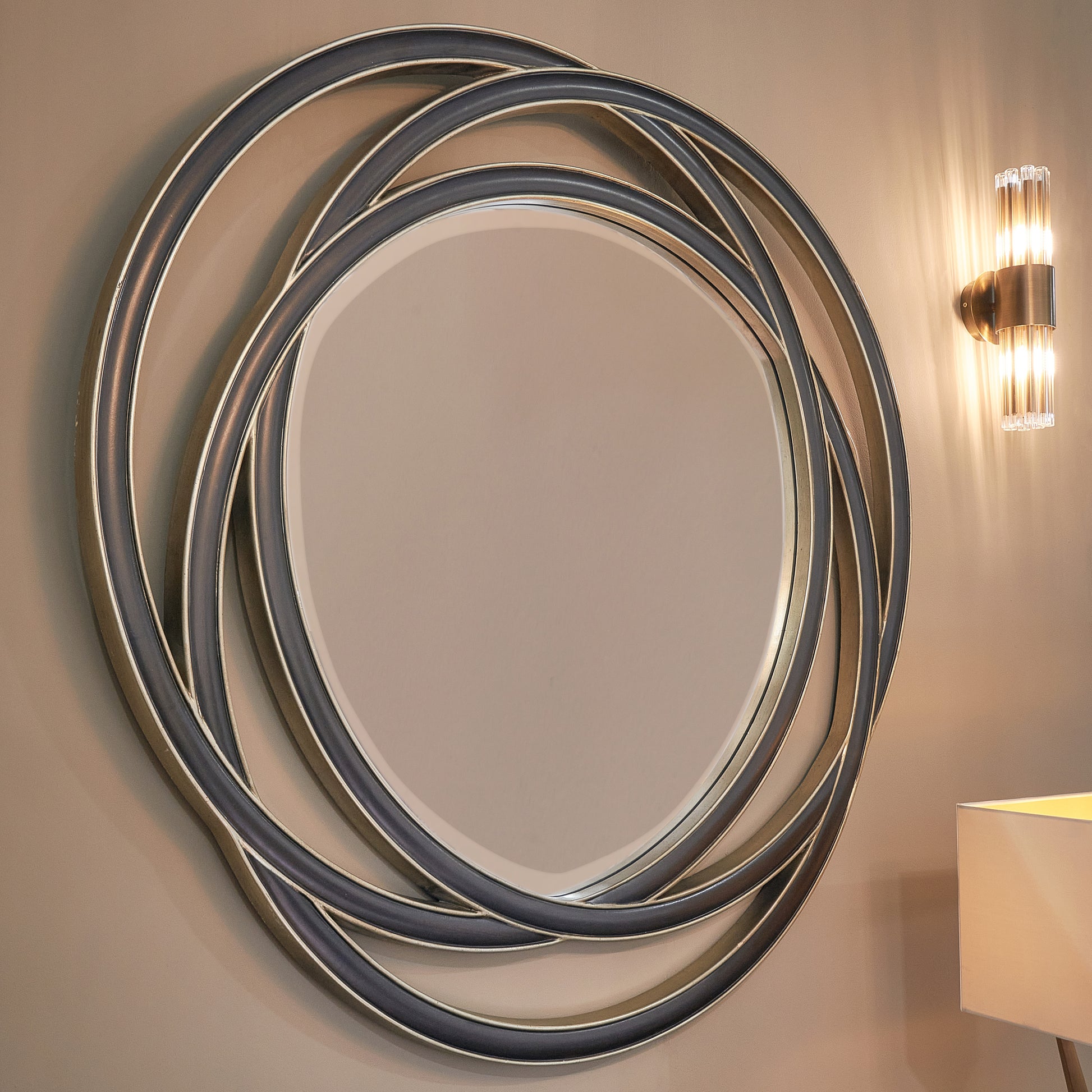Contemporary round mirror with interlocking metal ring frame.