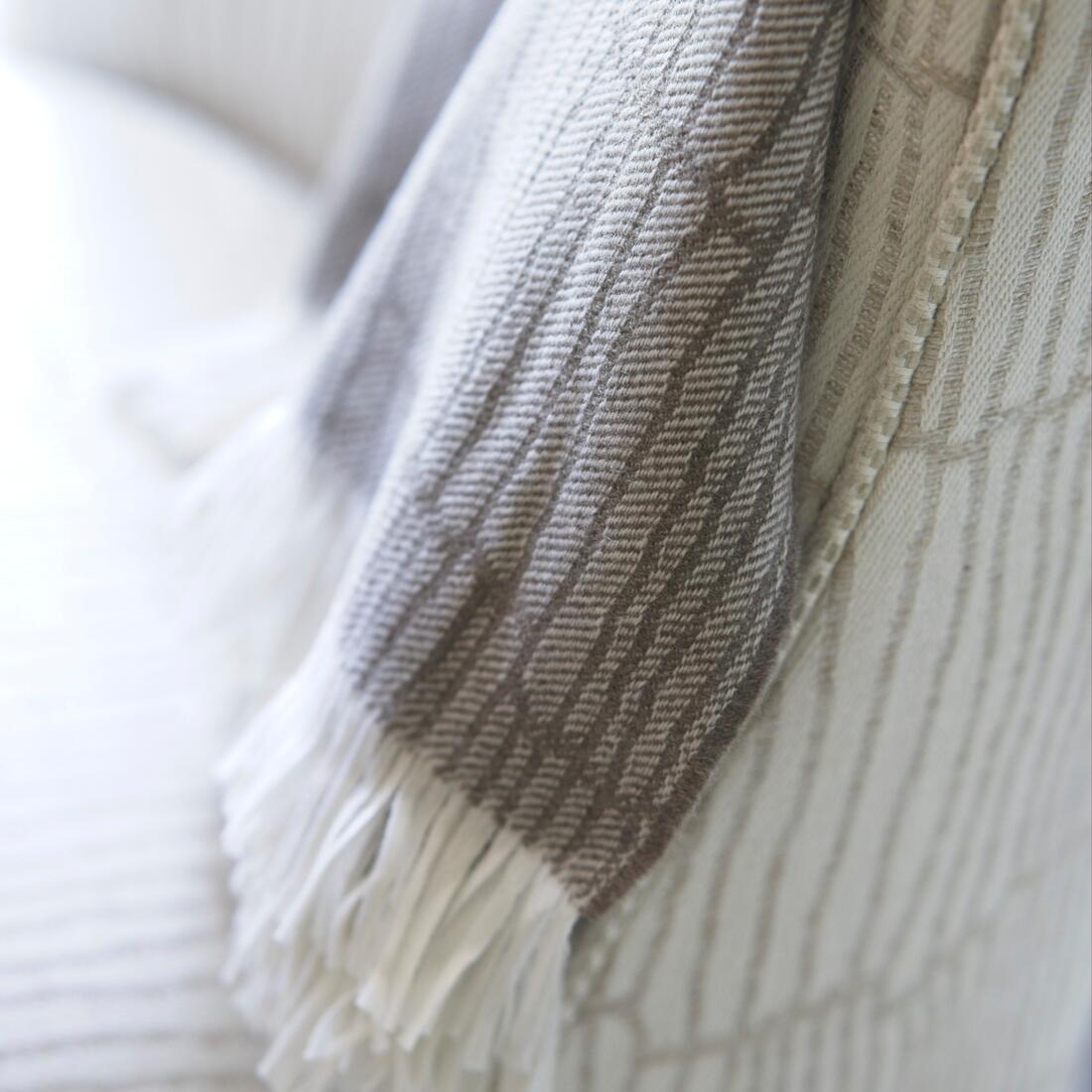 Andrew Martin tan Merino wool throw with geometric pattern and fringe